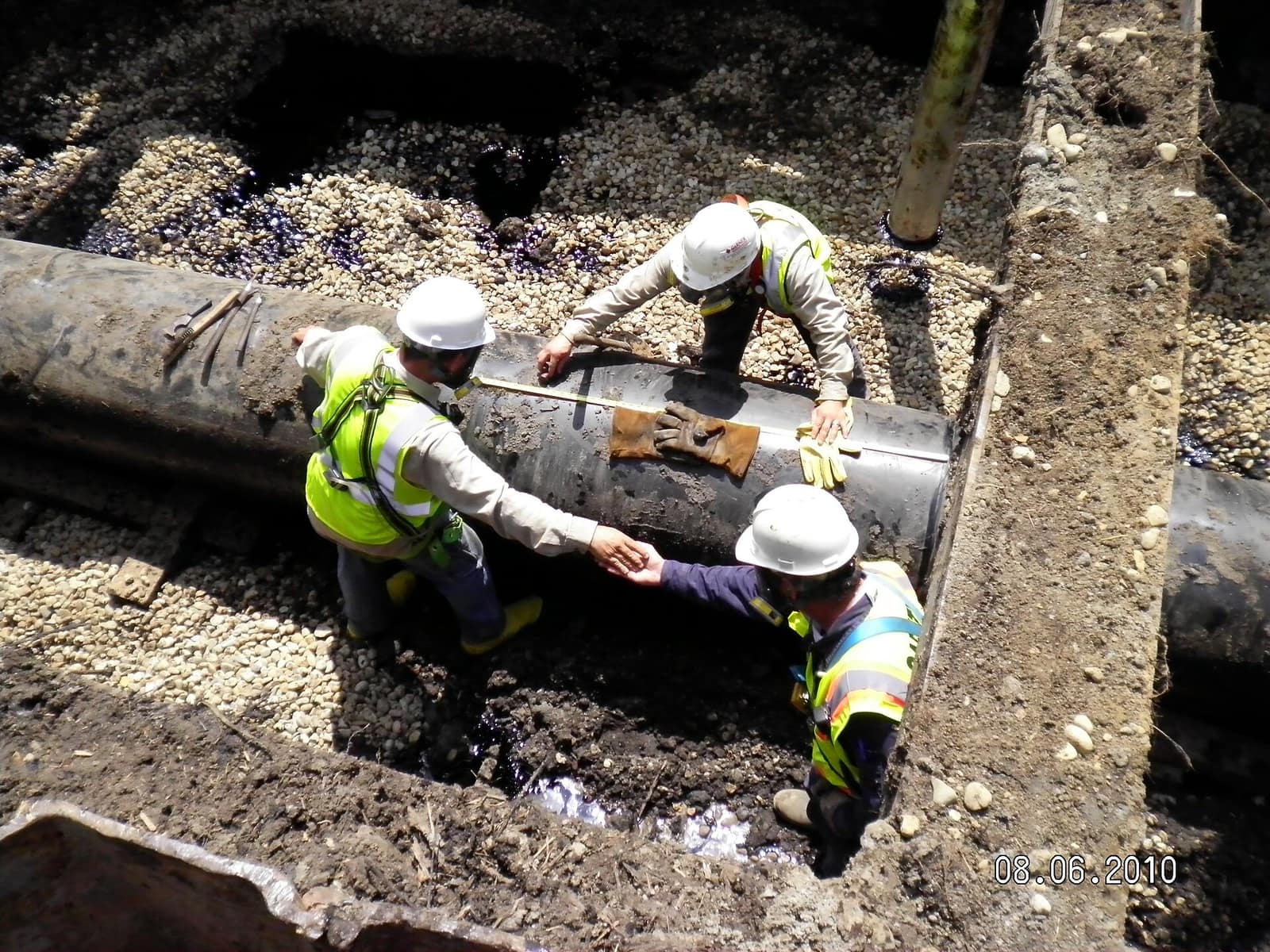 A crew working in personal protective equipment on a pipeline