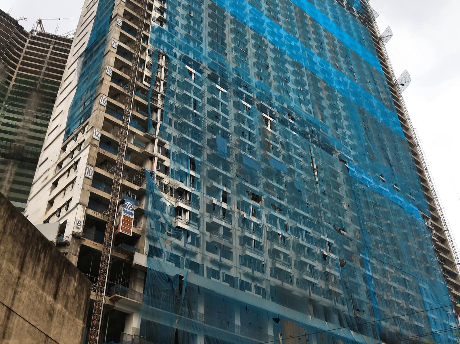 A building under construction wrapped in scaffolding and safety netting
